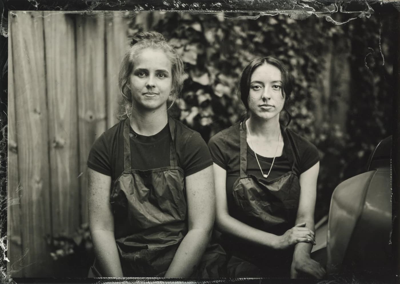 Handmade tintype portrait of two people seated together.